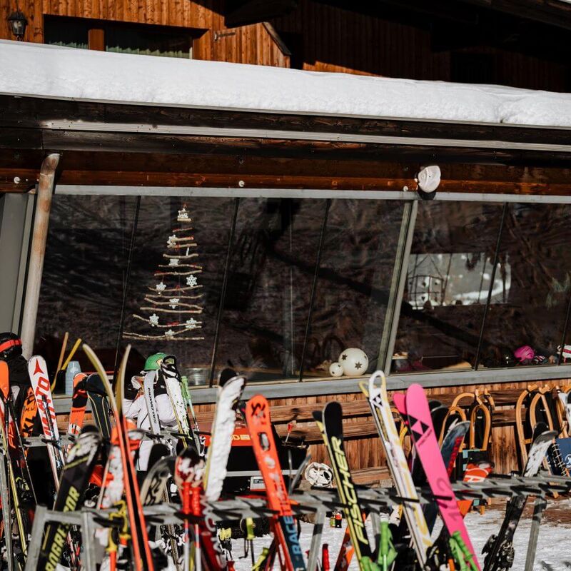 Skis and sledges in front of a mountain restaurant on the Bergeralm