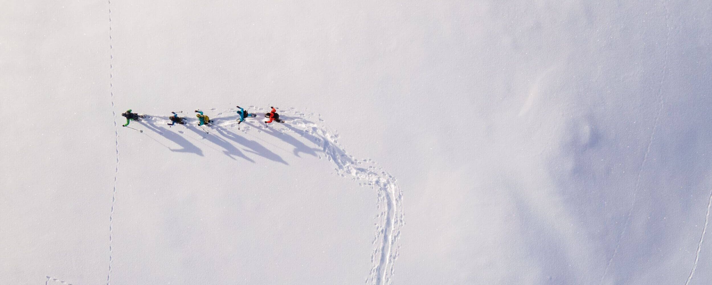 erial view of snowshoe hikers crossing the snowy winter landscape of the Raurisertal