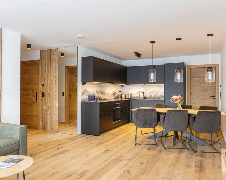 Helle Ferienwohnung mit offener Wohnküche, Esstisch und Holzboden in den Fiss Suites