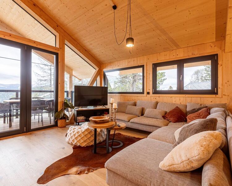 Cozy living area in a vacation home with a view of the Swiss stone pine forest