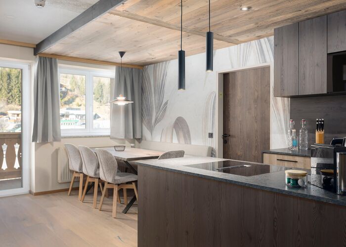 Living area with kitchen and dining table in the background   in the heart of Kaprun