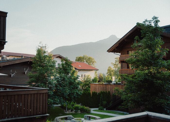 Buitenaanzicht van Bergresort Zugspitze Ehrwald in de zomer met een groene omgeving en uitzicht op de Tiroolse bergen.