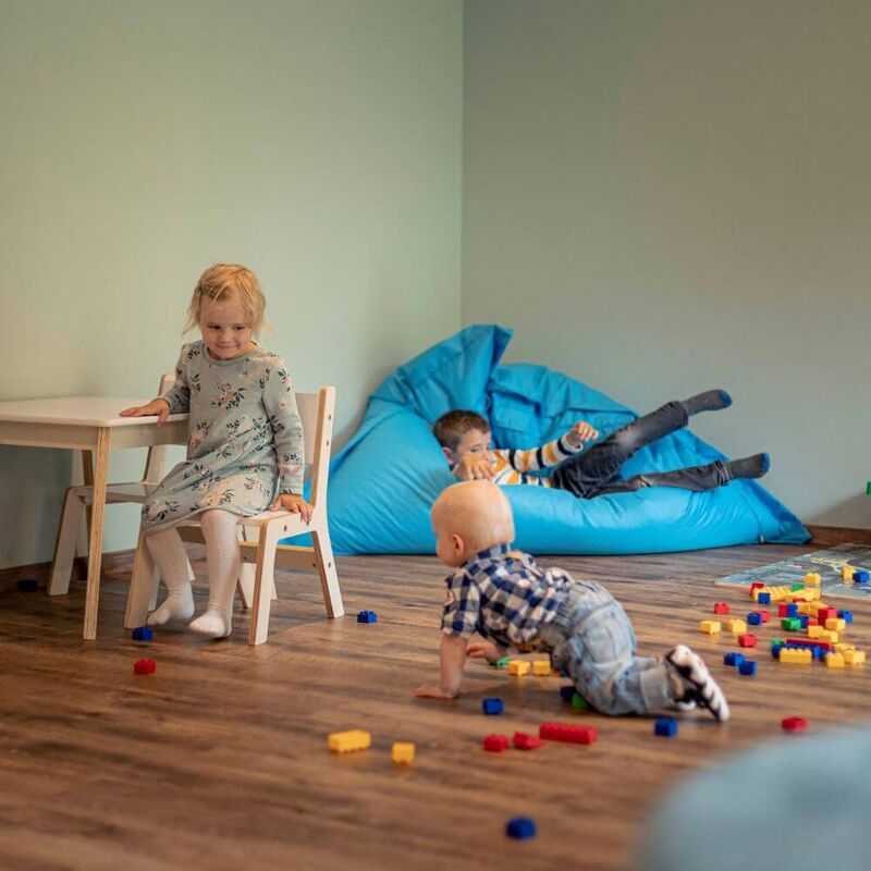 Kleine Kinder spielen mit Bauklötzen und Sitzsack