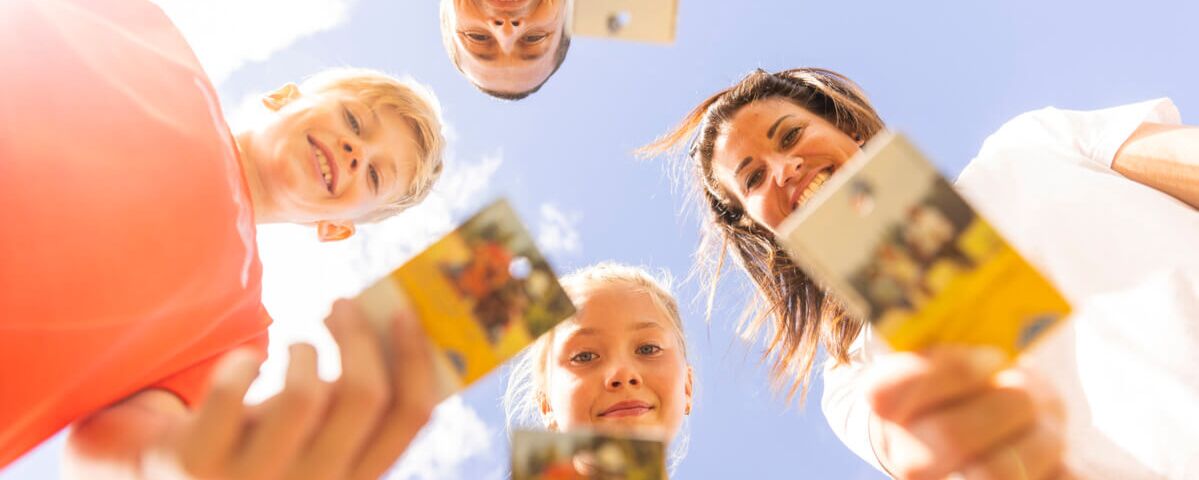 Familie hält die Super.Sommer.Card in die Kamera