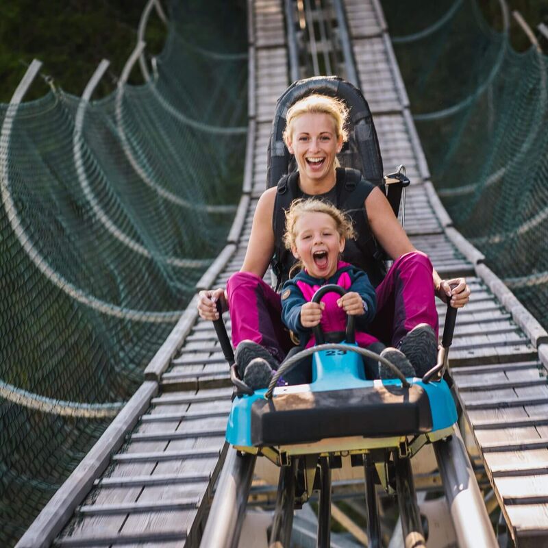 Mutter und Tochter genießen eine rasante Fahrt mit der Sommerrodelbahn auf der Turracher Höhe
