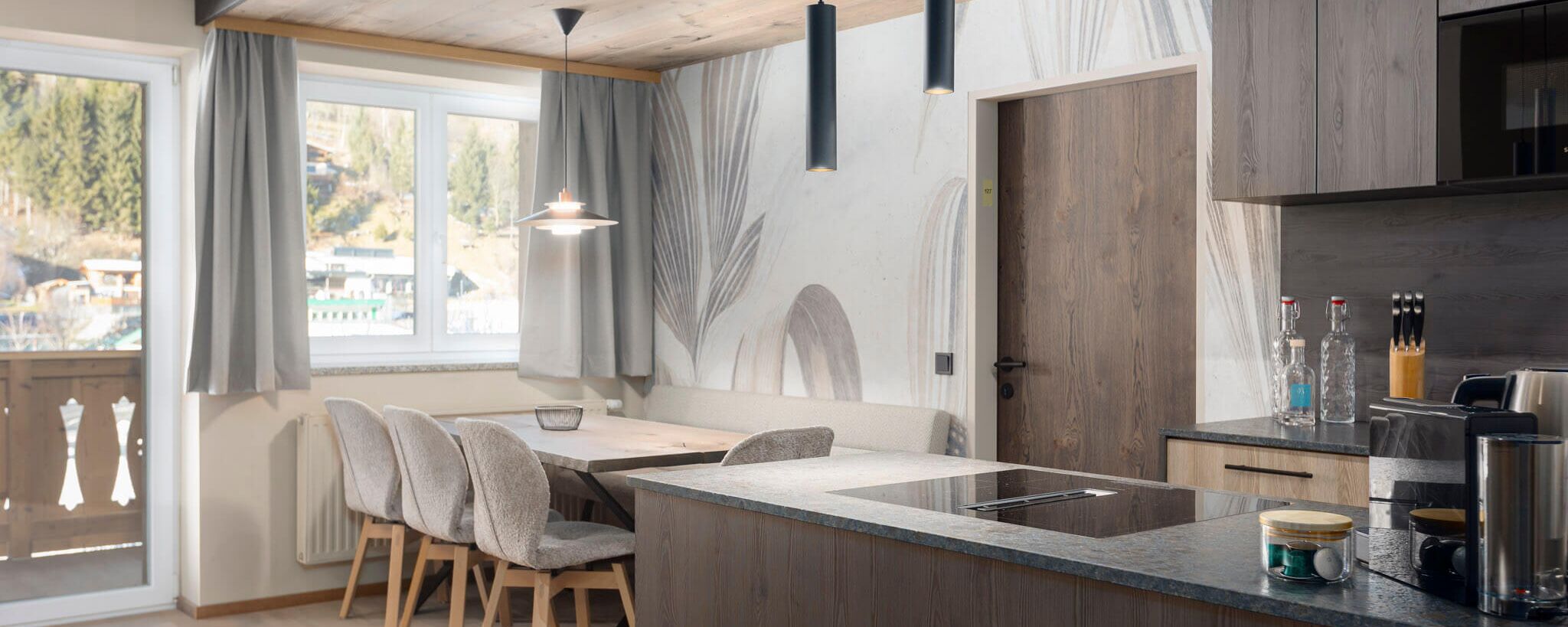 Living area with kitchen and dining table in the background   in the heart of Kaprun