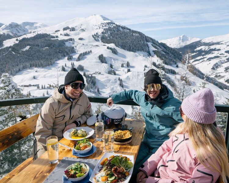 Friends eat typical regional dishes at the ski hut