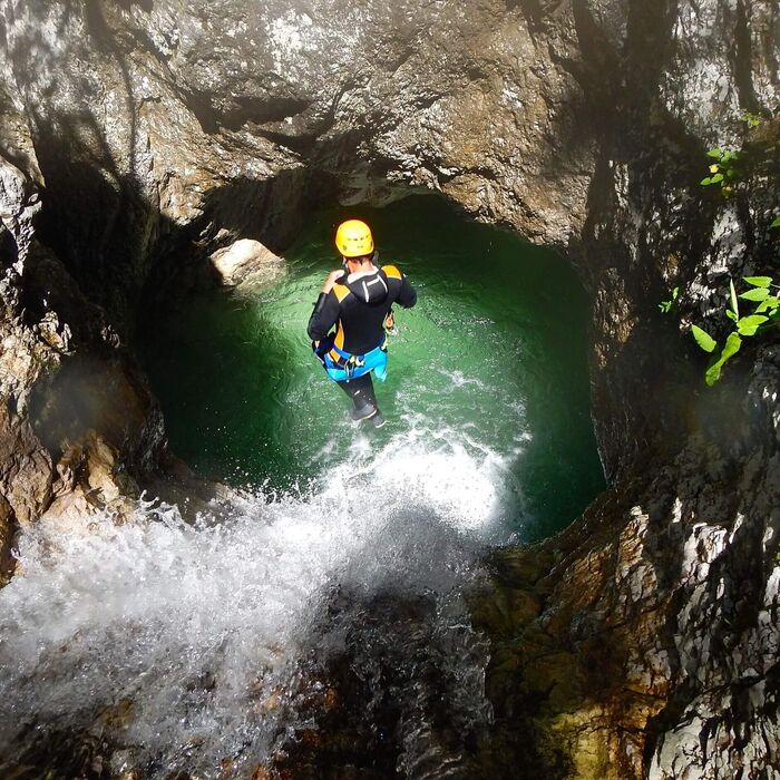 Canyoning group navigating the Mauthner Gorge between rock walls, waterfalls, and clear mountain water