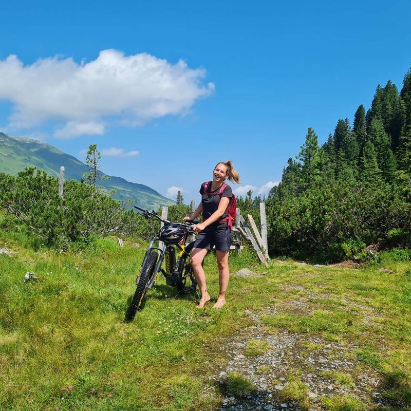 Biker in the Kitzbühel Alps pushes her e bike barefoot for a while.