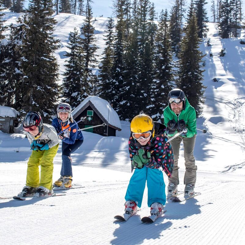 Familie beim Skifahren in winterlicher Landschaft auf der Grebenzen
