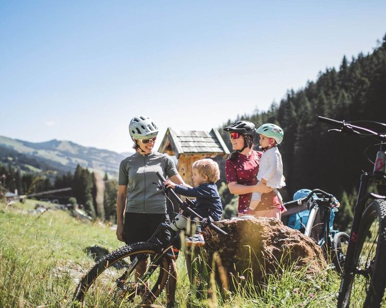 Family mountain biking in the mountain landscape of Saalbach.