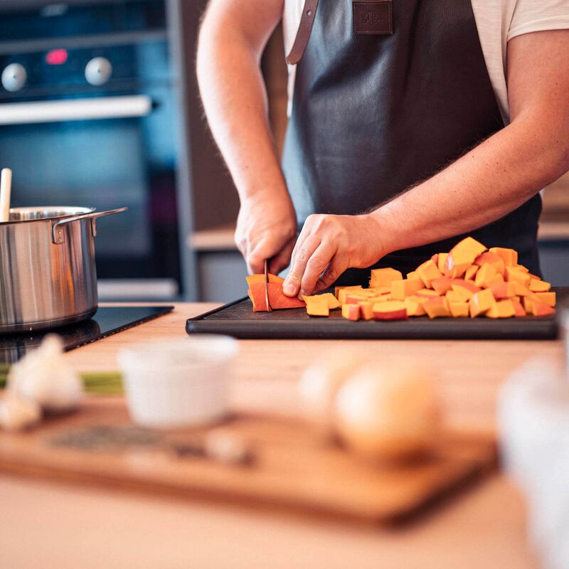 A man is chopping vegetables to prepare a meal for the holiday.