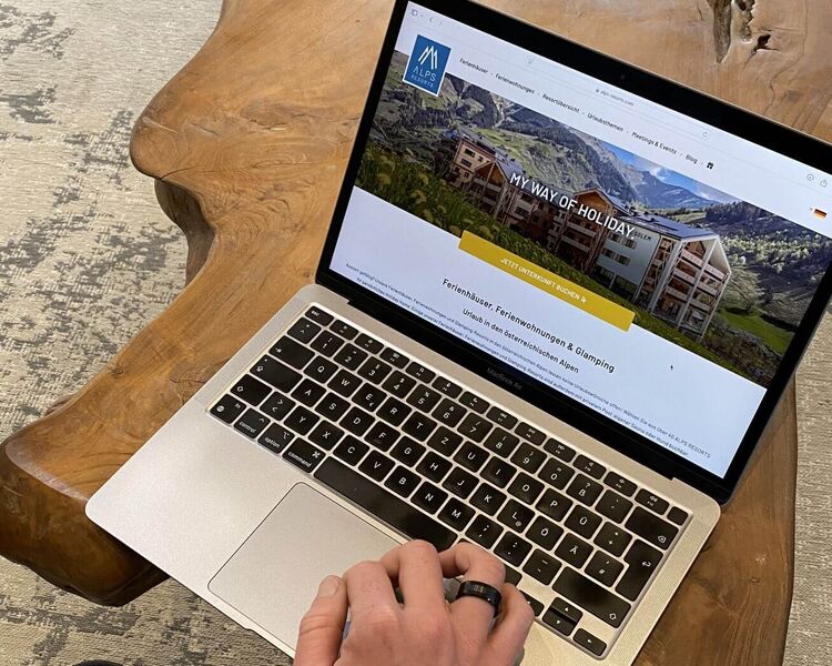 Someone is using a laptop to look for suitable holiday accommodation on the ALPS RESORTS website.