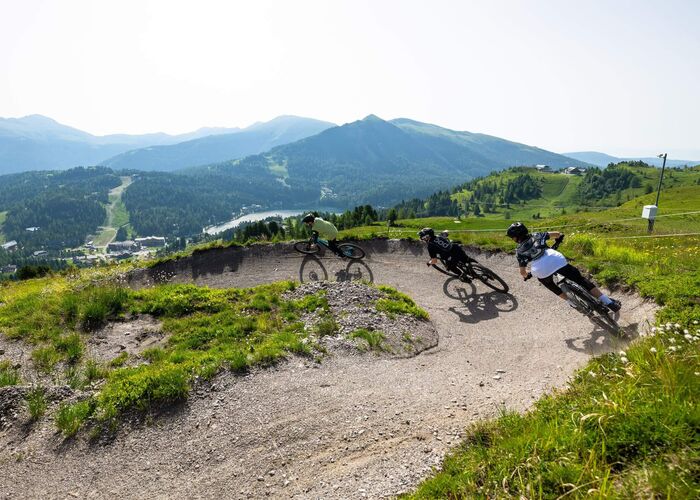 Radfahrer meistern eine dynamische Kurve auf dem Flowtrail Turracher Höhe in Kärnten