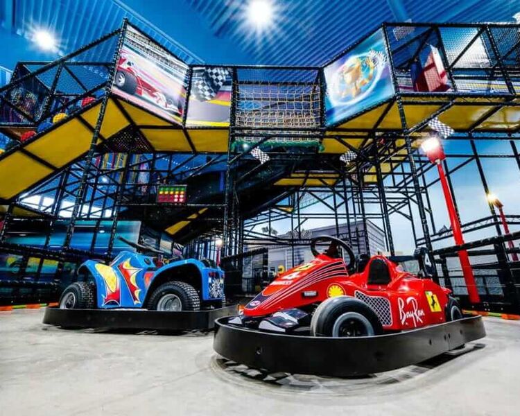 Spielbereich mit bunten Karts und einem aufregenden Klettergerüst für Kinder im Indoor-Freizeitpark.