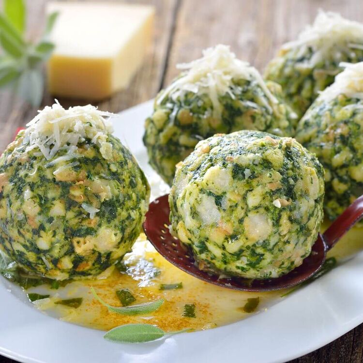 Grüne Spinatknödel auf einem Teller zeigen, wie einfach Meal Prep für die Ferienwohnung sein kann.