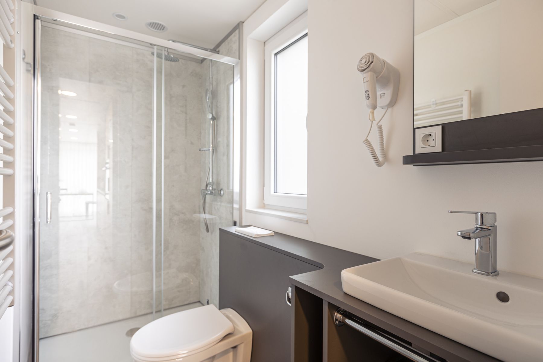 Badezimmer mit Dusche und Waschtisch im Chalet mit 2 Schlafzimmern im Chalets & Glamping Nassfeld
