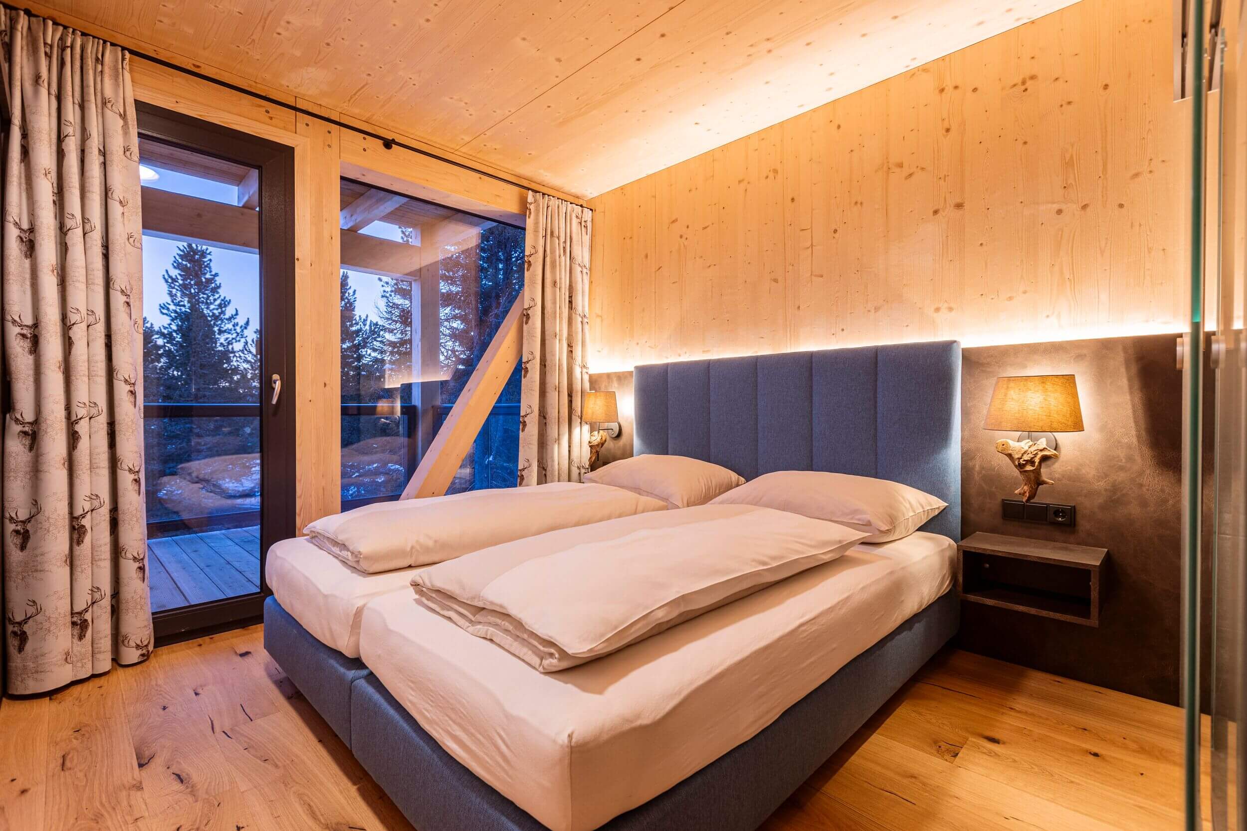 Schlafzimmer in einem Naturchalet auf der Turracher Höhe mit komfortablem Doppelbett, Holzelementen und alpiner Einrichtung für erholsamen Chalet-Urlaub in den Bergen.