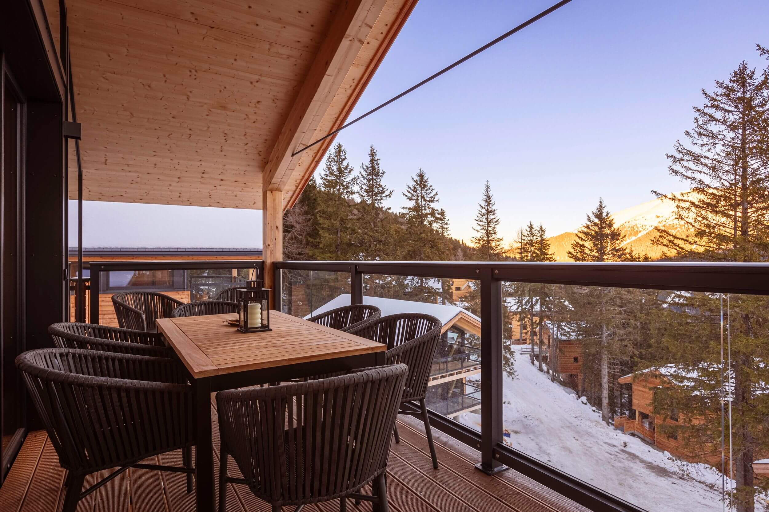 Balkon eines Naturchalets auf der Turracher Höhe im Winter mit Blick auf verschneite Bäume und die winterliche Berglandschaft.