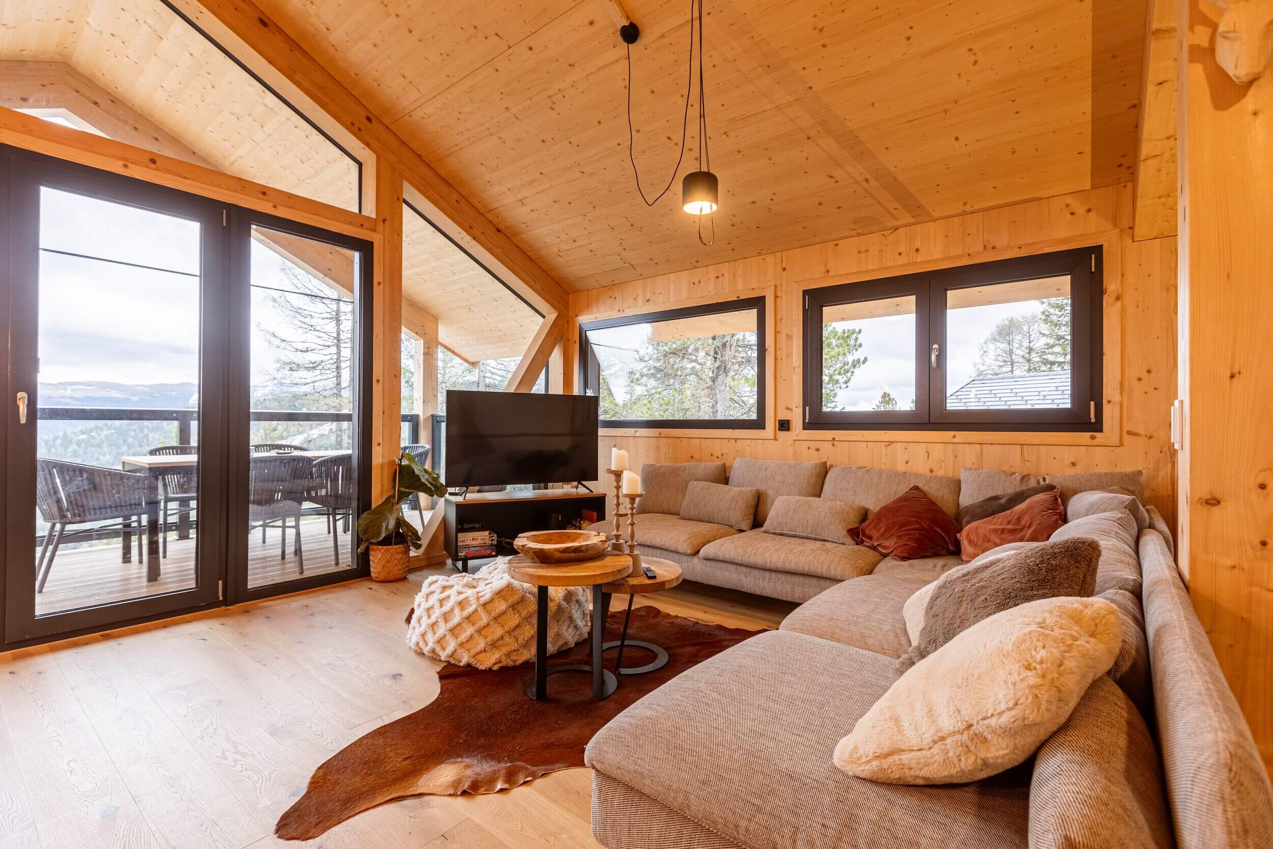 Gemütlicher Wohnbereich in einem Chalet auf der Turracher Höhe mit großem Sofa, Couchtisch und alpiner Einrichtung – ideal für einen Chaleturlaub in den Bergen.