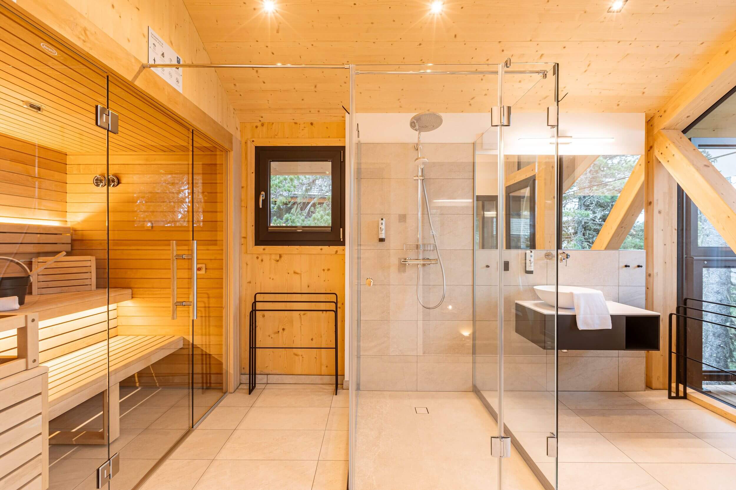 Hochwertiges Badezimmer in einem Chalet auf der Turracher Höhe mit Waschtisch, Spiegel und natürlichen Materialien für einen komfortablen Chaleturlaub in den Bergen.