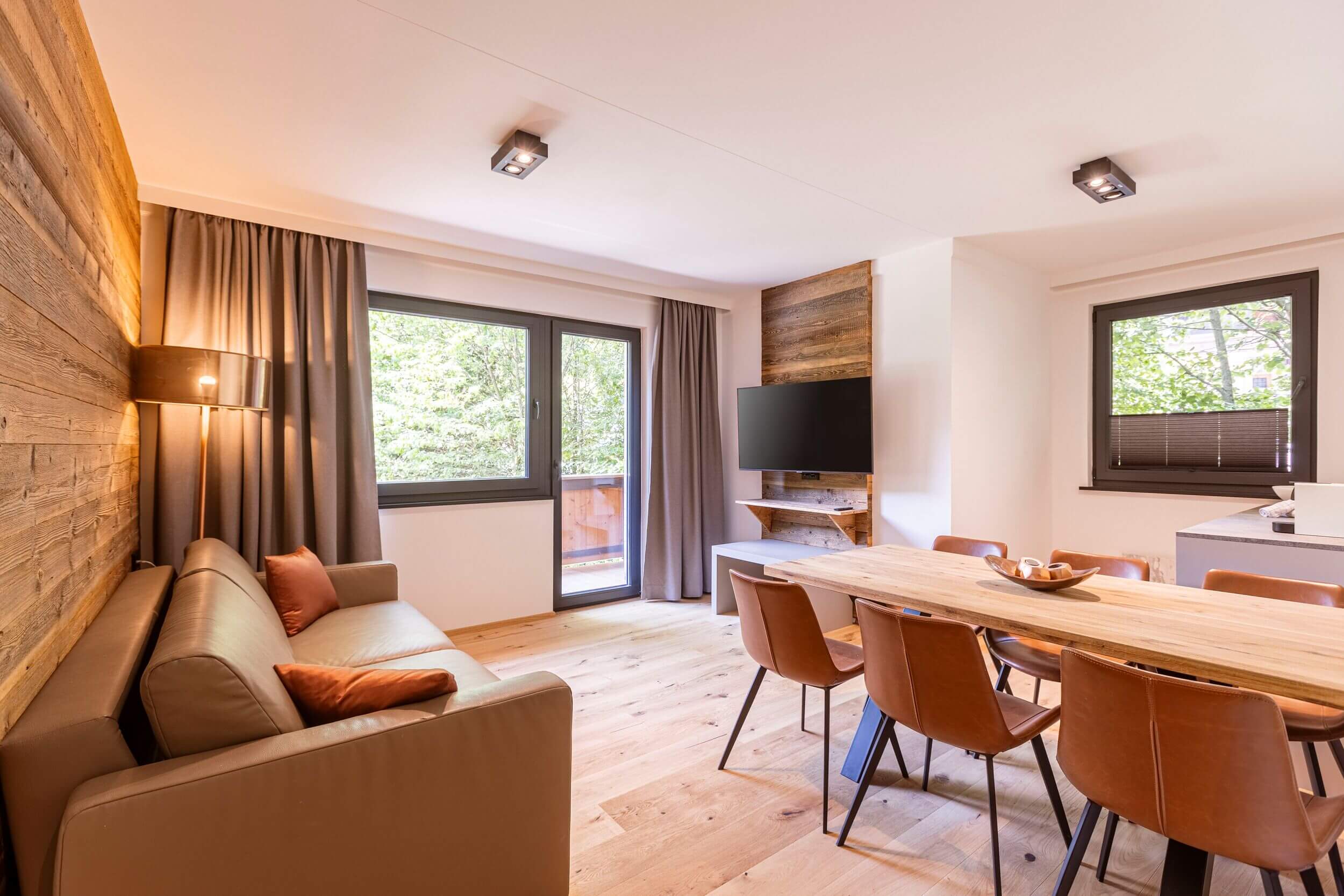 Gemütlicher Wohnbereich einer Ferienwohnung in den Saalbach Suites in Vorderglemm bei Saalbach mit komfortablem Sofa und stilvoller Einrichtung.